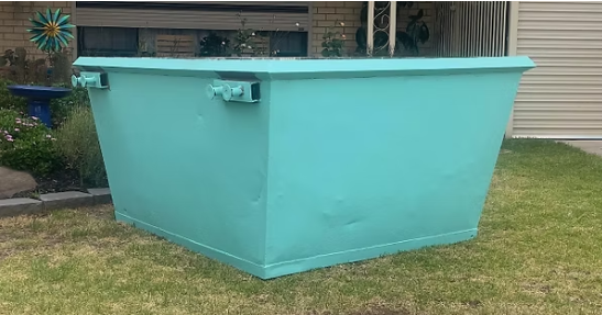 2 cubic meter turquoise mini skip bin hire Adelaide - compact waste bin on residential lawn for small cleanups and garden waste